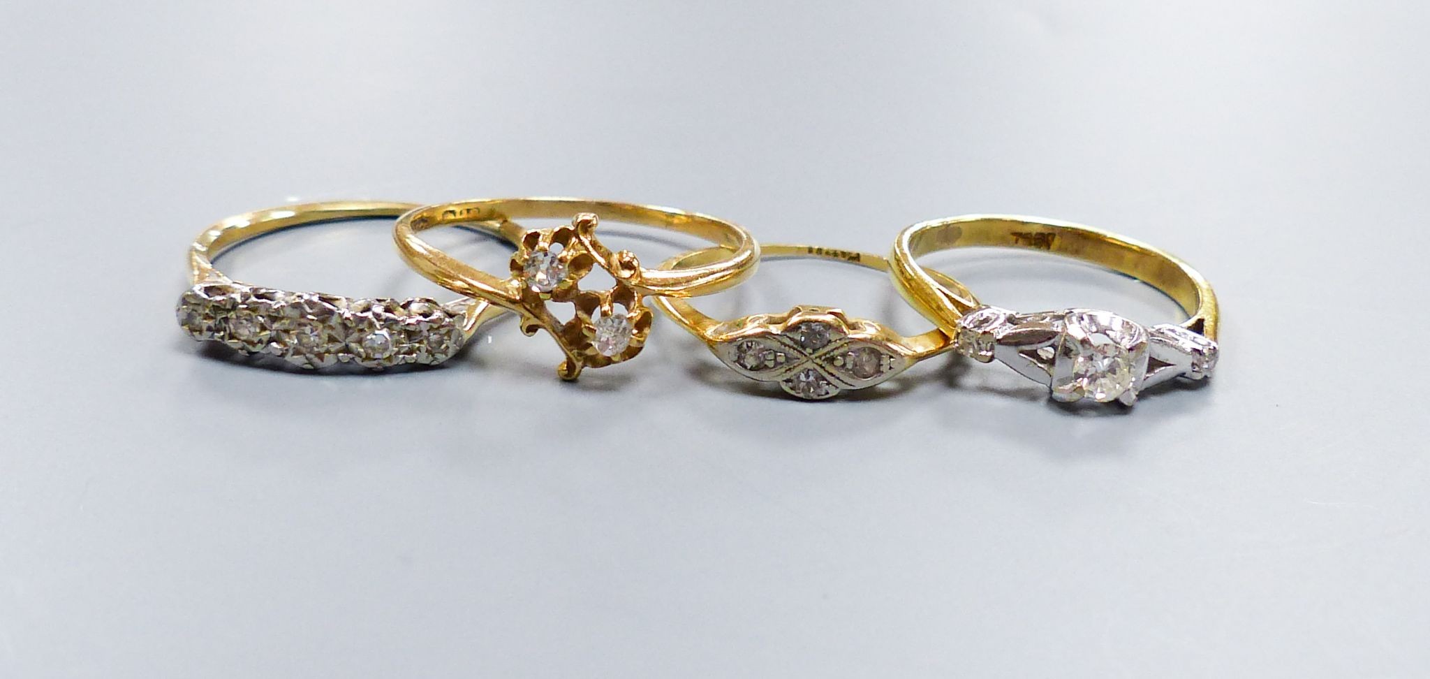 Three assorted 18ct and diamond set rings, including two stone crossover, gross 6.5 grams and a yellow metal and five stone illusion set diamond half hoop ring, gross 2.1 grams.